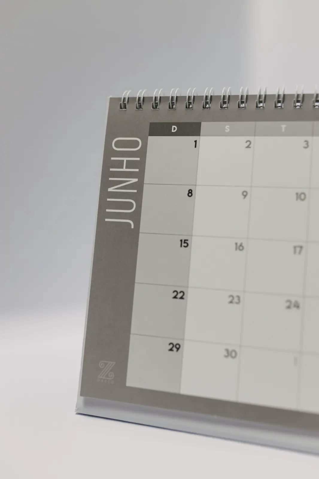 A close view of a paper desk calendar open to a month, with the days of the week across the top.